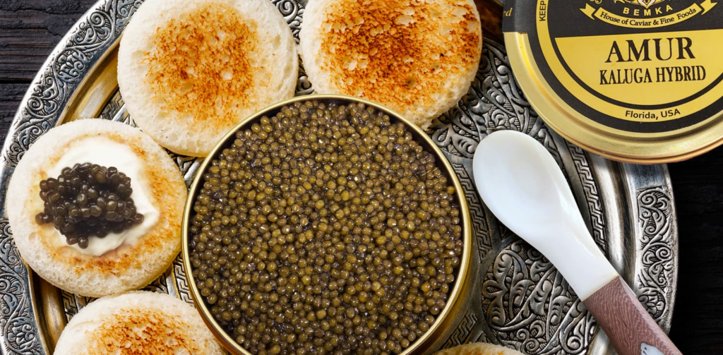 A tin of caviar next to some blinis