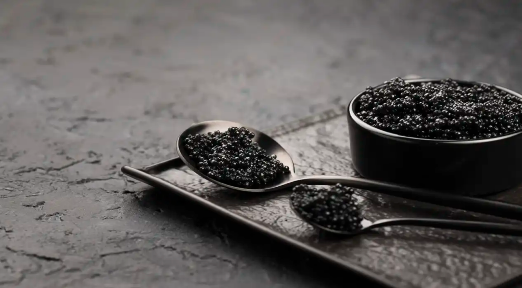 A tin and two spoons of black caviar